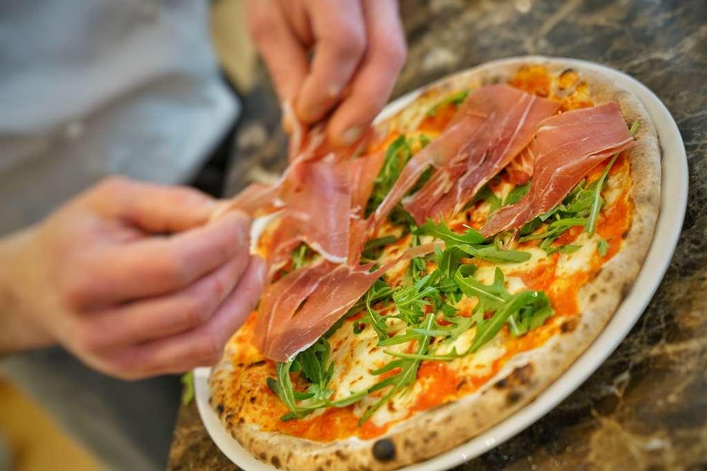 Vila Vita Rosenpark Marburg Luaran gambar Pizza being topped with prosciutto